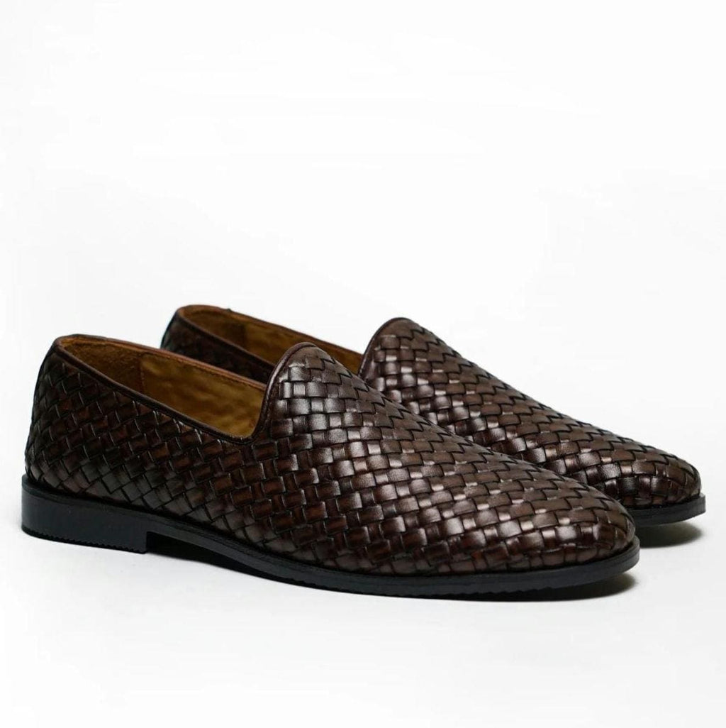 Pair of men's woven leather loafers with dark brown finish, slip-on design, and textured woven pattern, isolated on white background.
